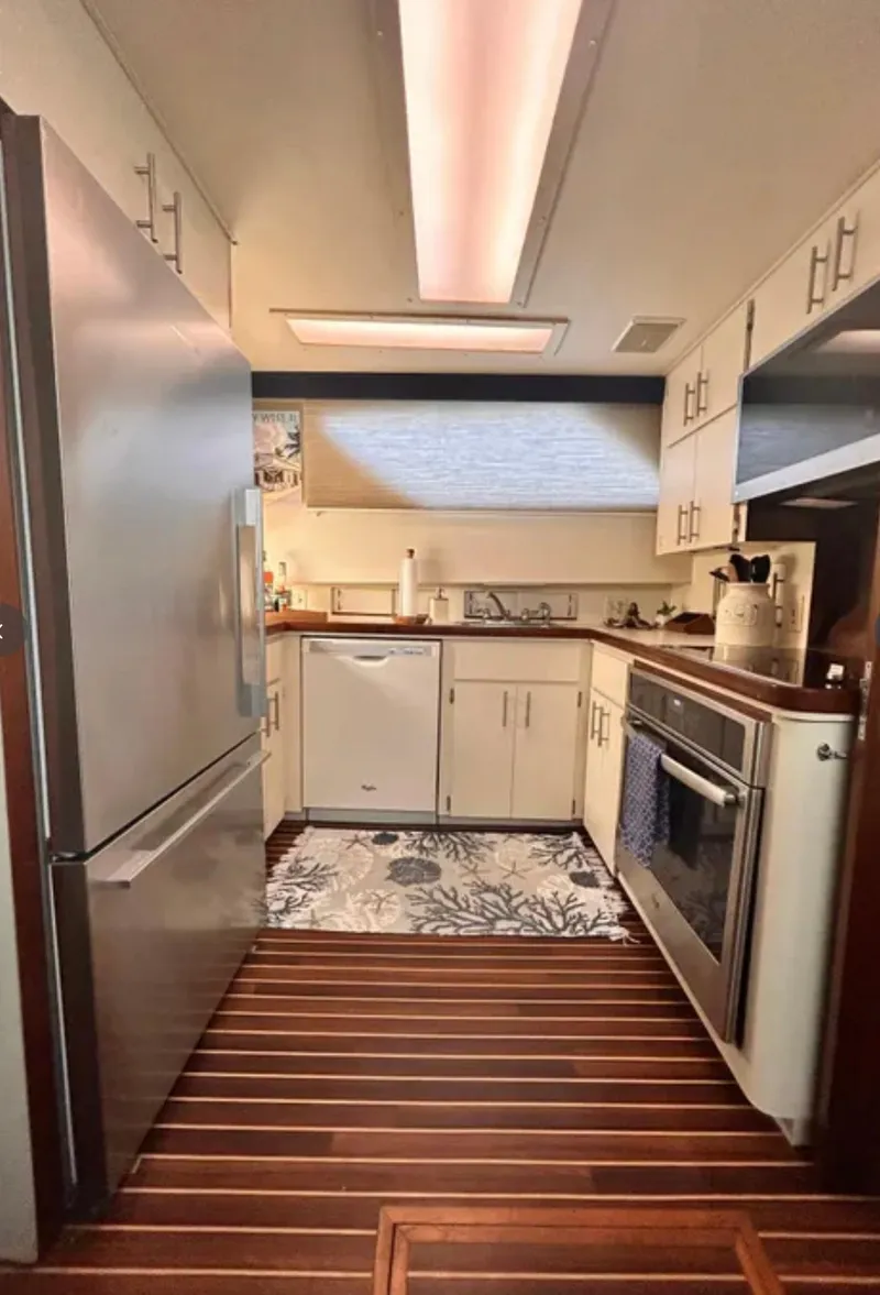 Slide: The Image of 1989 Hatteras 67 Cockpit Motor Yacht kitchen with modern appliances and wood flooring. - 16
