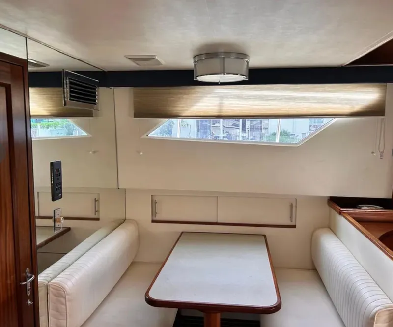 Slide: The Image of Interior of 1989 Hatteras 67 Cockpit Motor Yacht with dining area and modern decor. - 13