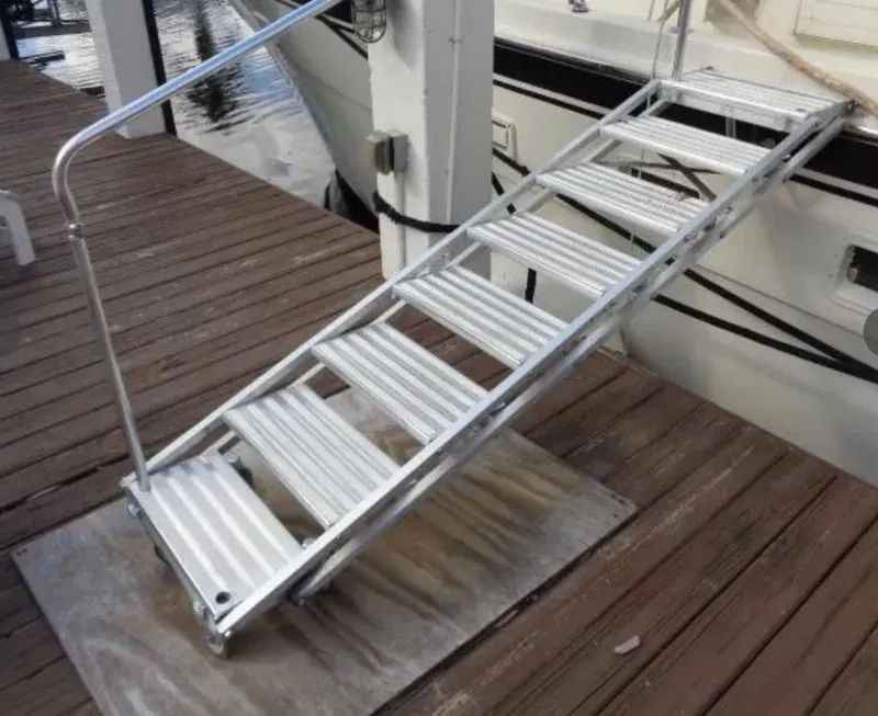 Slide: The Image of Aluminum gangway leading to a 1989 Hatteras 67 Cockpit Motor Yacht on a wooden dock. - 42