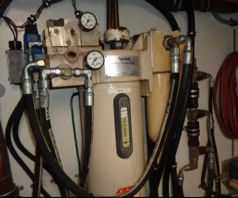 Slide: The Image of Engine room equipment on 1989 Hatteras 67 Cockpit Motor Yacht, featuring gauges and hoses. - 32