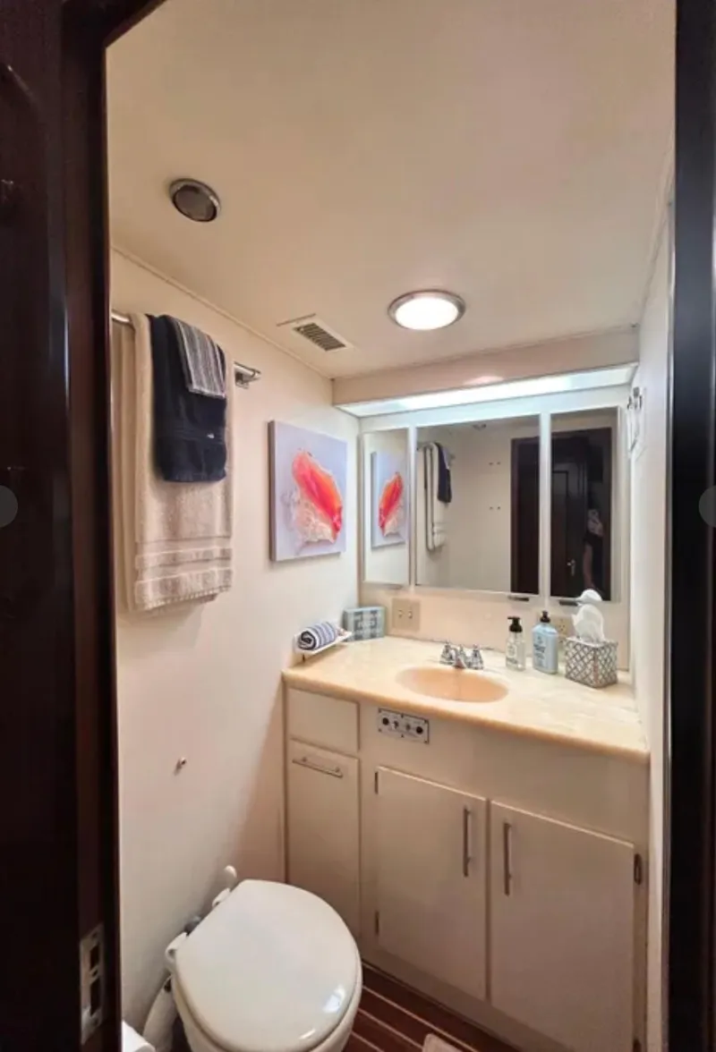 Slide: The Image of Bathroom interior of 1989 Hatteras 67 Cockpit Motor Yacht, featuring sink, mirror, and decor. - 14