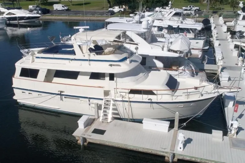 Slide: The Image of 1985 Hatteras 58 Motor Yacht docked at marina, surrounded by other boats. - 1