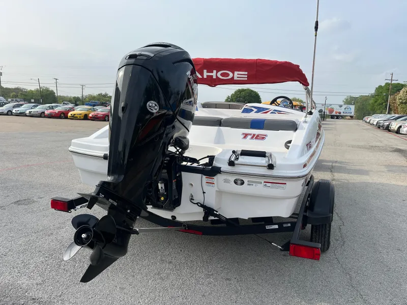 Slide: The Image of 2022 Tahoe T16 boat with outboard motor on trailer, parked in a lot. - 10