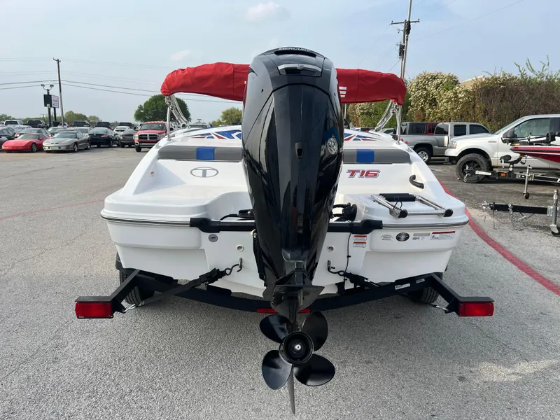 Slide: The Image of 2022 Tahoe T16 boat with outboard motor, parked on a trailer in a lot. - 11