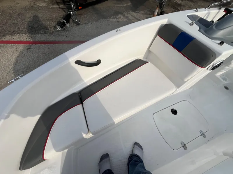 Slide: The Image of 2022 Tahoe T16 boat interior with white and gray seating, red accents, and storage compartment. - 28