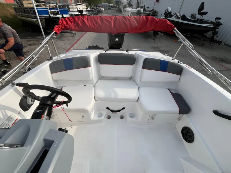 Slide: The Image of 2022 Tahoe T16 boat interior with seating and steering wheel, docked outdoors. - 32
