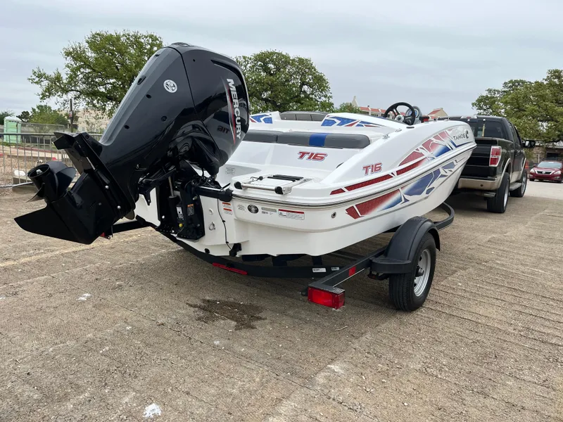 Slide: The Image of 2022 Tahoe T16 boat on trailer, parked outdoors, with visible outboard motor. - 43