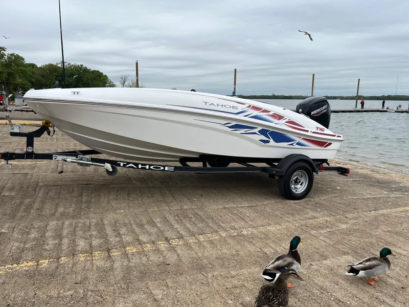 Slide: The Image of 2022 Tahoe T16 boat on trailer by lake, with ducks nearby. - 47