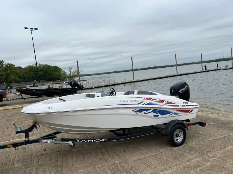 Slide: The Image of 2022 Tahoe T16 boat on trailer by lakeside dock. - 48