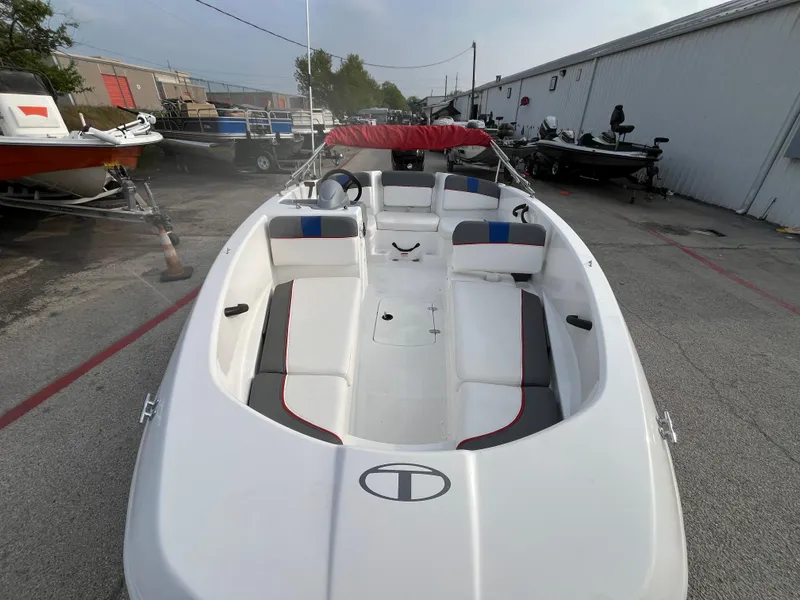Slide: The Image of 2022 Tahoe T16 boat with red canopy, parked in a marina. - 5