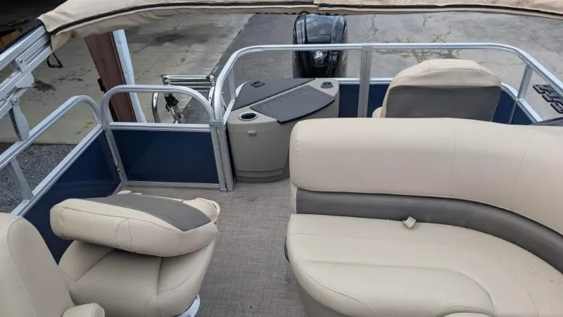 Slide: The Image of 2024 Sun Tracker Bass Buggy 18 DLX pontoon boat interior with beige seating and blue accents. - 7