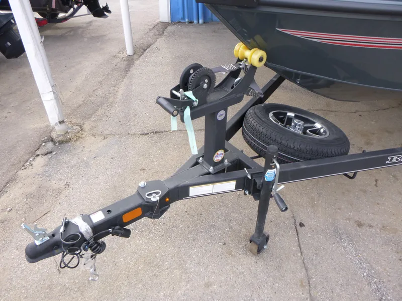 Slide: The Image of 2024 Ranger VS1665SC boat trailer hitch with spare tire on concrete surface. - 2