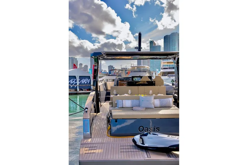 Slide: The Image of 2022 Tesoro T40 Inboard yacht docked, featuring luxurious seating and city skyline backdrop. - 13