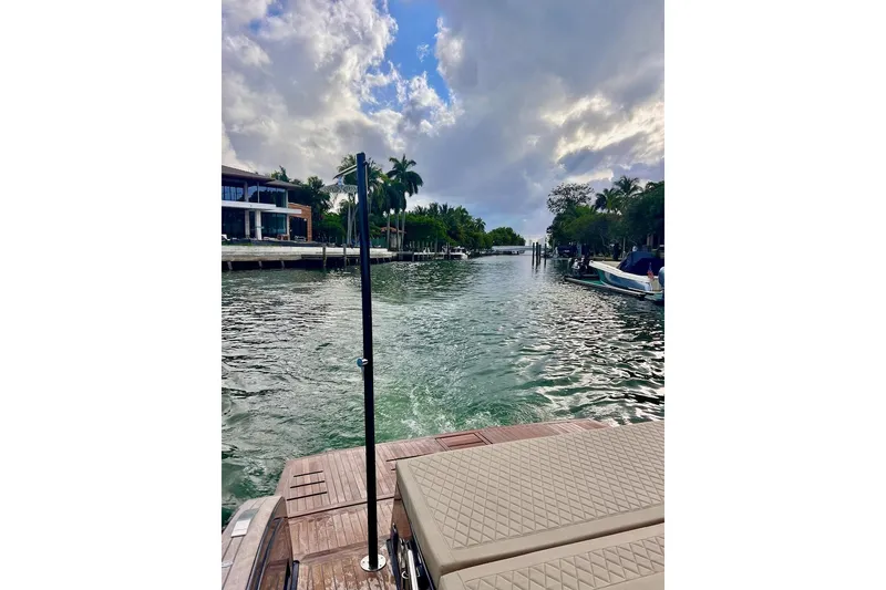Slide: The Image of 2022 Tesoro T40 Inboard boat on a scenic waterway with palm trees and cloudy sky. - 7