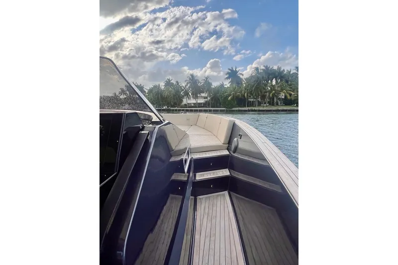 Slide: The Image of 2022 Tesoro T40 Inboard boat on water, with palm trees and cloudy sky in background. - 8