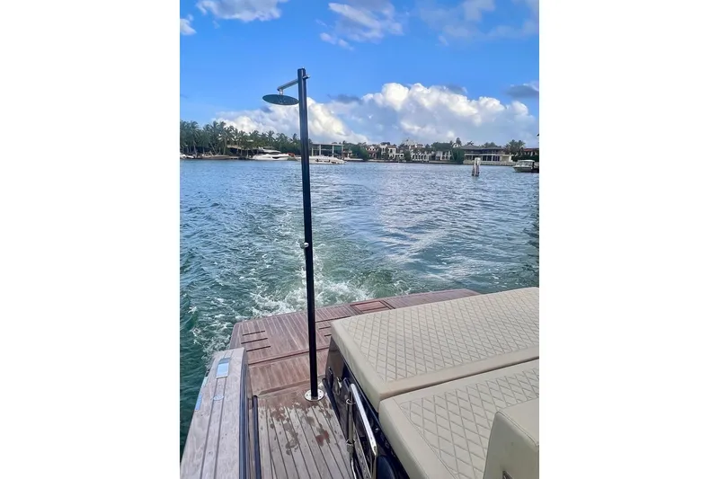 Slide: The Image of 2022 Tesoro T40 Inboard boat on water, featuring a spacious deck and scenic view. - 9