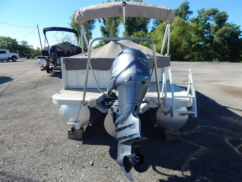 Slide: The Image of 2016 Bennington 24 SSLX pontoon boat with outboard motor, parked on gravel. - 3