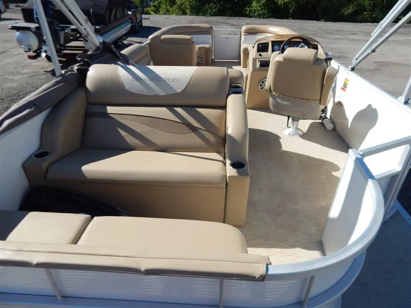 Slide: The Image of 2016 Bennington 24 SSLX pontoon boat interior with beige seating and steering console. - 4