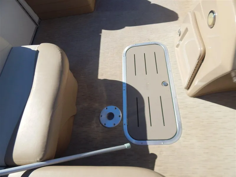 Slide: The Image of 2016 Bennington 24 SSLX boat interior with beige seating and floor hatch. - 8