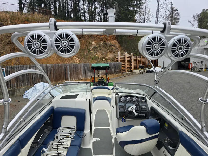 Slide: The Image of 2009 Yamaha Boats AR230 HO interior with speakers and seating, parked outdoors. - 13