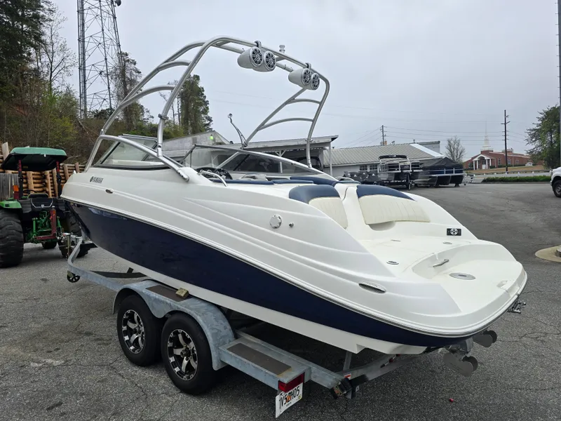 Slide: The Image of 2009 Yamaha Boats AR230 HO on trailer, sleek design, white and blue exterior. - 2
