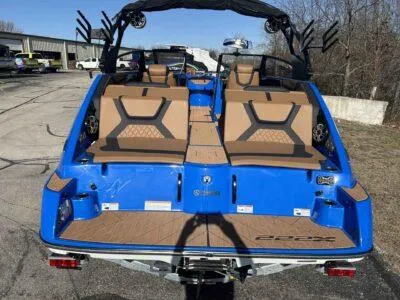 Slide: The Image of 2025 Yamaha Boats 222XE, blue exterior, tan seating, docked outdoors. - 4