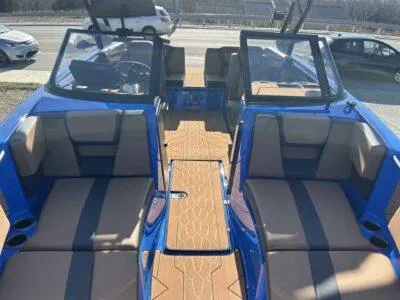 Slide: The Image of 2025 Yamaha Boats 222XE interior with blue and tan seating, dual windshields, and modern design. - 5