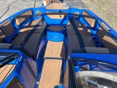 Slide: The Image of 2025 Yamaha Boats 222XE interior with blue and tan seating, speakers, and cup holders. - 8