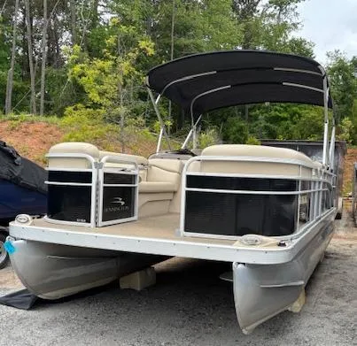 Slide: The Image of 2014 Bennington 22 SSX pontoon boat with canopy, parked on gravel. - 0
