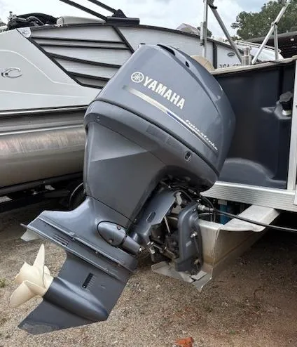 Slide: The Image of 2014 Bennington 22 SSX with Yamaha outboard motor, docked on a trailer. - 12