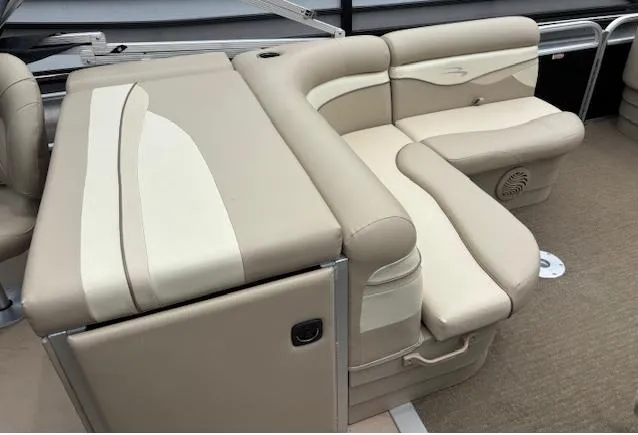 Slide: The Image of 2014 Bennington 22 SSX boat interior with beige seating and storage compartments. - 3