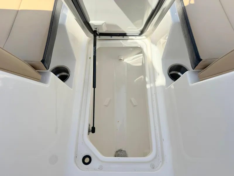 Slide: The Image of 2022 Sea Ray SPX 230 OB boat storage compartment with cup holders. - 11
