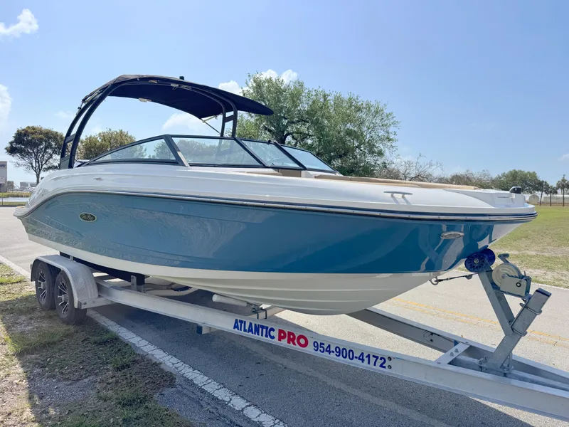 Slide: The Image of 2022 Sea Ray SPX 230 OB boat on trailer, blue and white design, parked outdoors. - 6