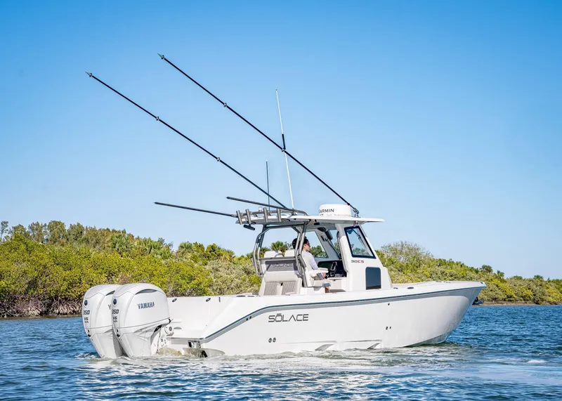 Slide: The Image of 2026 Solace 30 CS boat cruising on water with fishing rods and dual engines. - 0