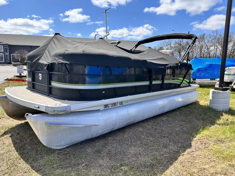 Slide: The Image of 2018 Sweetwater 2286 pontoon boat with cover, parked on grass under a blue sky. - 9