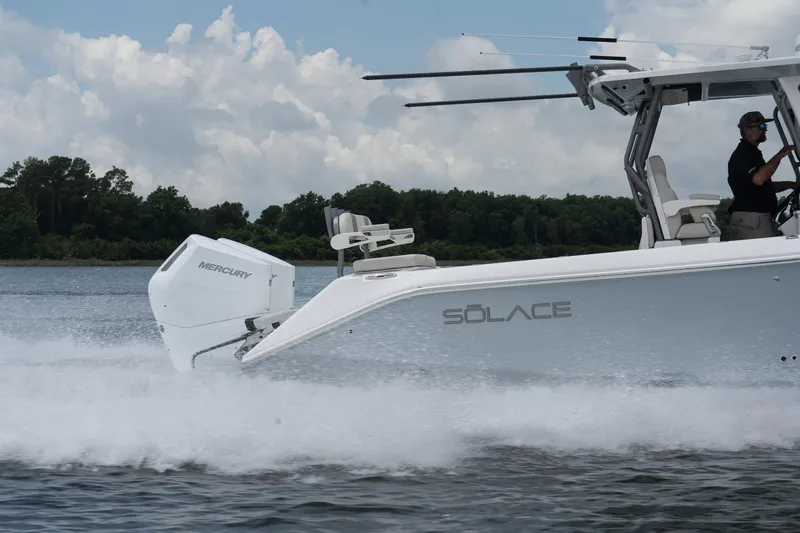 Slide: The Image of 2026 Solace 32 CS boat cruising on water with Mercury engine, side view. - 10