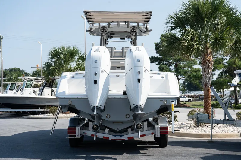 Slide: The Image of 2025 Solace 32 CS boat with dual engines on a trailer, surrounded by palm trees. - 15