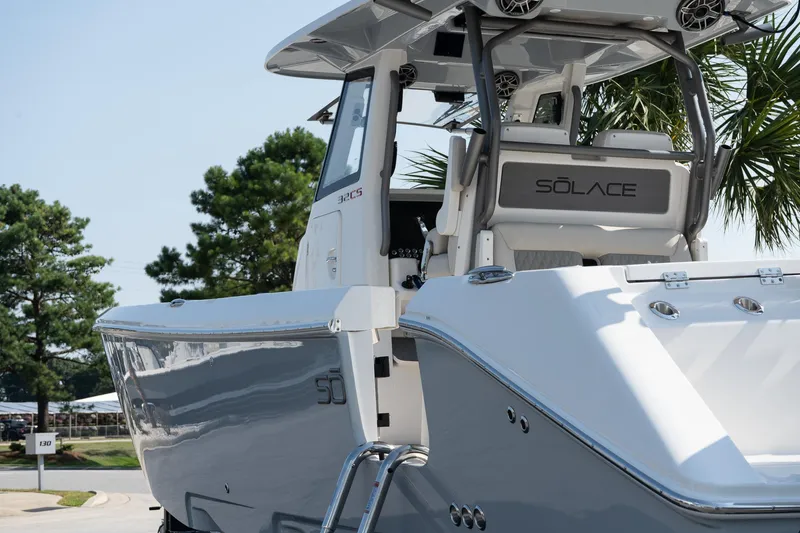 Slide: The Image of 2025 Solace 32 CS boat, sleek design, parked outdoors with trees in the background. - 18