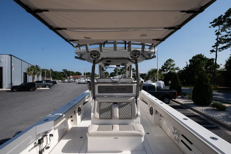 Slide: The Image of 2026 Solace 32 CS boat interior with seating and canopy, parked outdoors. - 23
