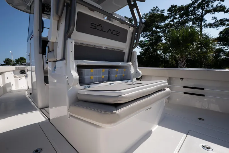 Slide: The Image of 2026 Solace 32 CS boat interior with seating and storage, surrounded by trees. - 27