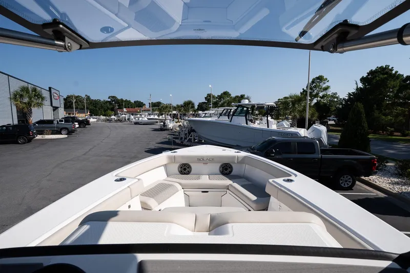 Slide: The Image of 2026 Solace 32 CS boat displayed at a dealership with other boats and vehicles. - 30