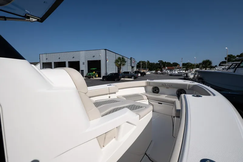 Slide: The Image of 2026 Solace 32 CS boat interior with cushioned seating, docked near a marina. - 33