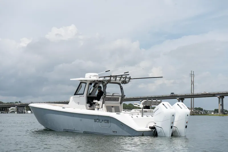 Slide: The Image of 2026 Solace 32 CS boat on water with twin engines, bridge in background. - 5