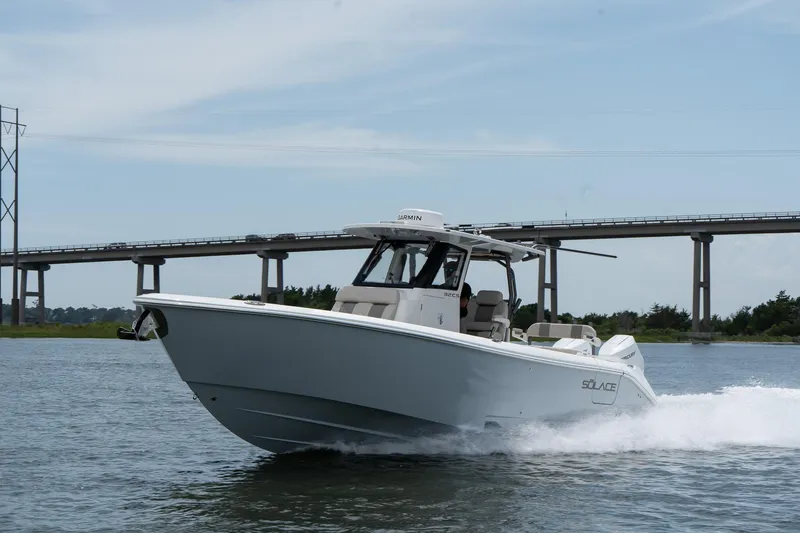 Slide: The Image of 2026 Solace 32 CS boat cruising on water near a bridge. - 7