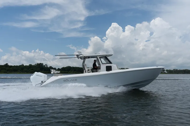 Slide: The Image of 2026 Solace 32 CS boat cruising on water under a cloudy sky. - 9