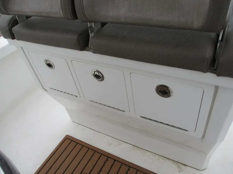 Slide: The Image of 2020 Crevalle 26 HCO boat storage compartments with cushioned seating. - 13