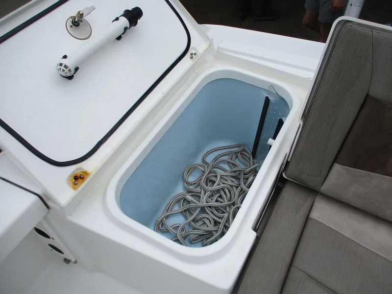 Slide: The Image of 2020 Crevalle 26 HCO boat storage compartment with coiled rope and seating area. - 18