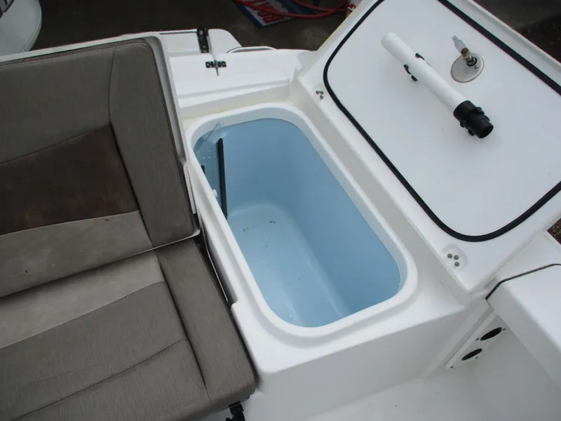 Slide: The Image of 2020 Crevalle 26 HCO boat storage compartment with open lid and seating area. - 19