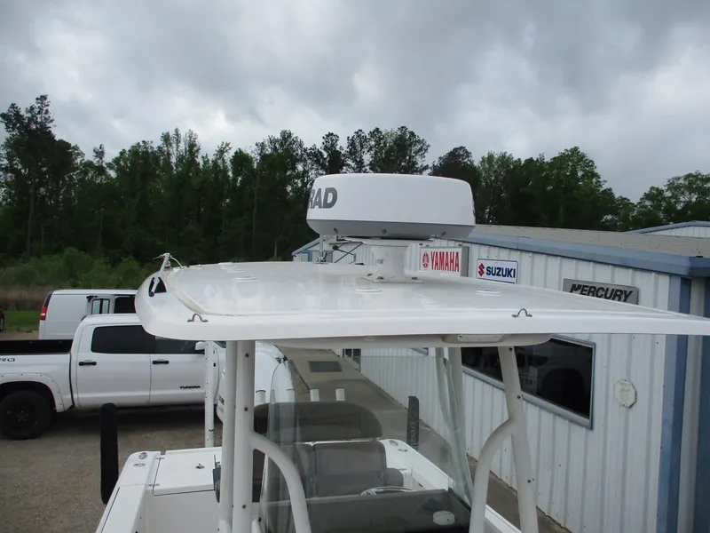 Slide: The Image of 2020 Crevalle 26 HCO boat with radar, parked near dealership, cloudy sky background. - 7