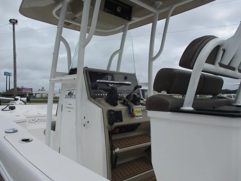 Slide: The Image of 2020 Crevalle 26 HCO boat interior with helm and seating under cloudy sky. - 9